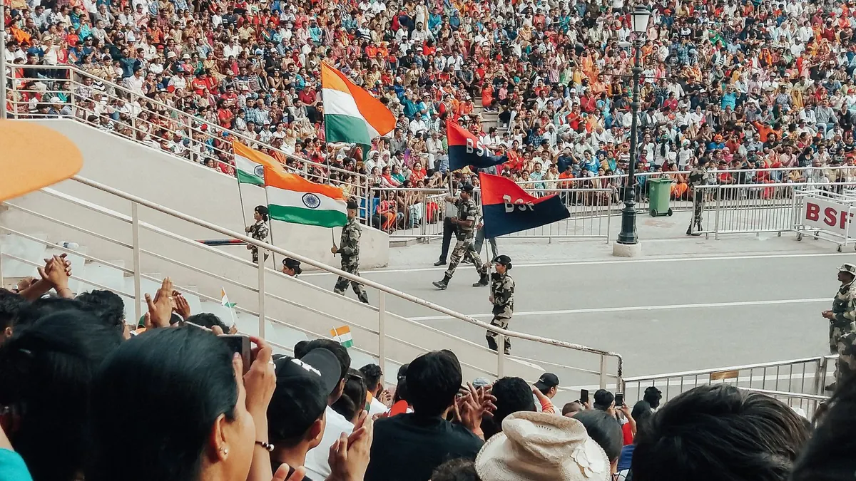 Celebration crowd at patriotic parade with soldiers and flags in vibrant stadium setting.