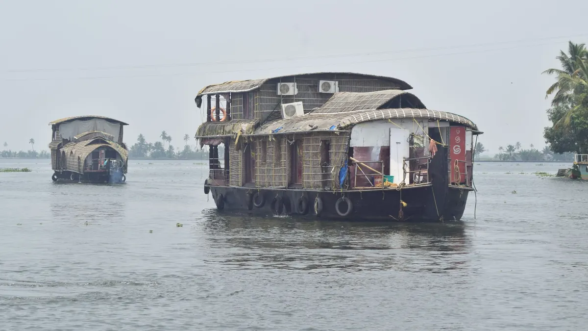 Traditional houseboats cruise the serene backwaters of Alappuzha, Kerala, India.
