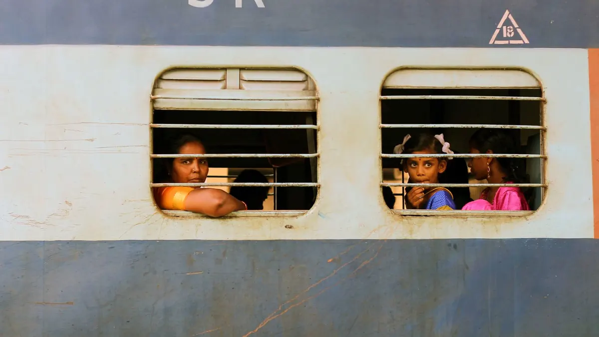 Three passengers peer out of a train window, capturing a moment of travel and curiosity.