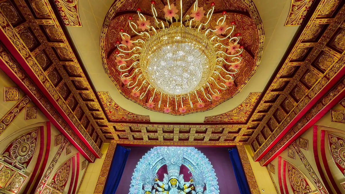 Stunning Durga idol under ornate ceiling chandelier during Durga Puja in Kolkata, India.