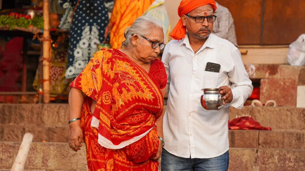 Elderly couple in traditional attire during a spiritual visit to the Ghats of Varanasi, India.