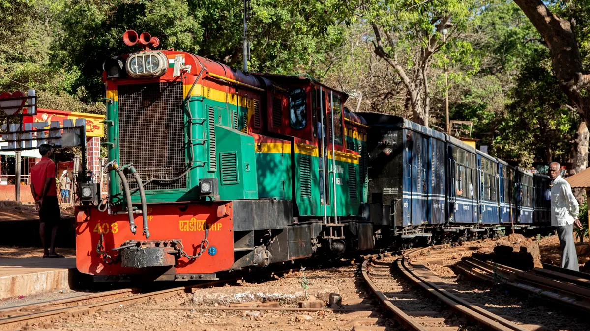 A vibrant narrow gauge train in Matheran, Maharashtra, highlighting local culture and travel routes.