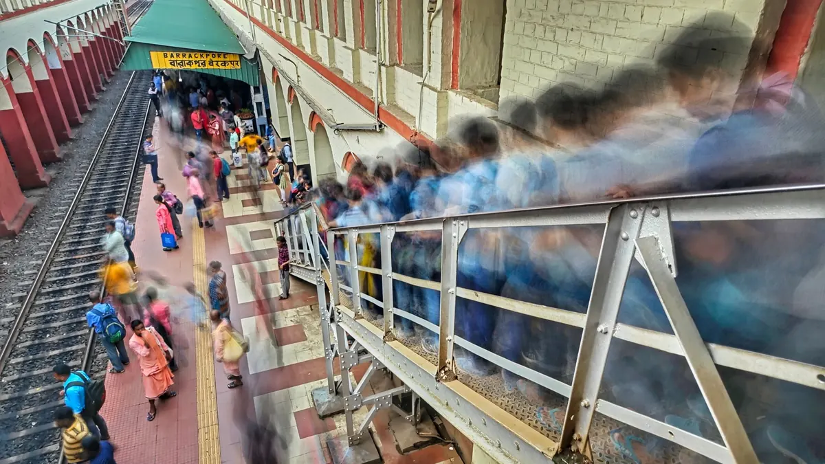 Blurred motion of commuters at Barrackpore railway station in India, showing daily rush.