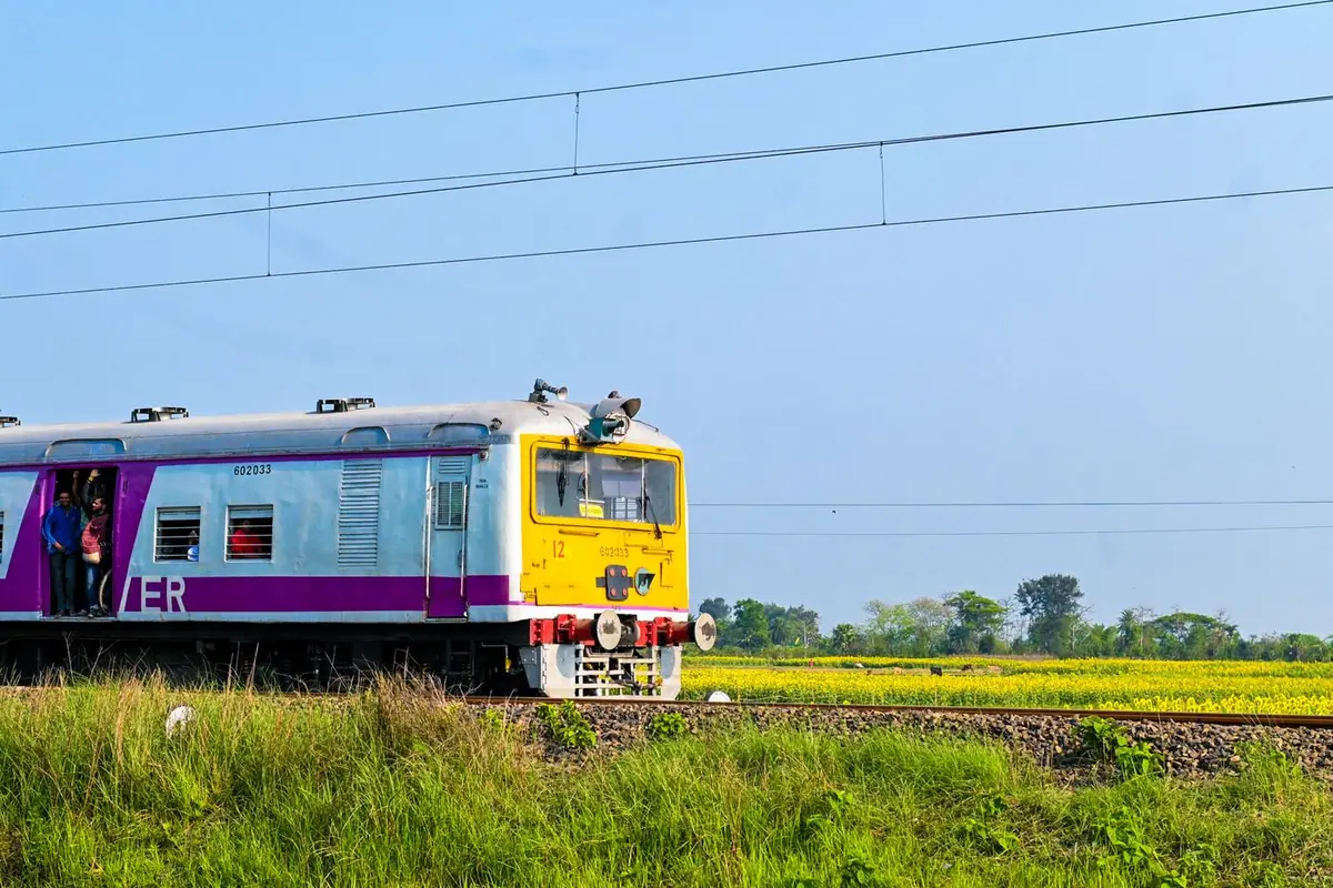 A local passenger train running through green fields